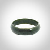 Hand carved jade bangle. Carved from green New Zealand jade. This is a solid jade bangle carved from a single piece of jade. It is polished to a soft shine. The jade is otherwise untreated and completely natural.